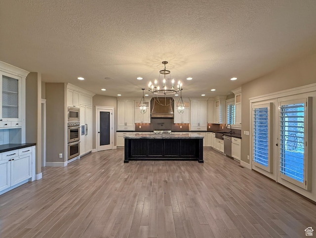 1663 N 3500 W, Plain City, UT 84404 - kitchen with stainless steel appliances, an inviting chandelier, a sink, wood finished floors, and premium range hood