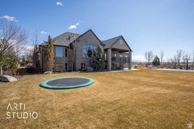 1663 N 3500 W, Plain City, UT 84404 - back of house featuring a lawn, a balcony, a trampoline, a patio area, and brick siding