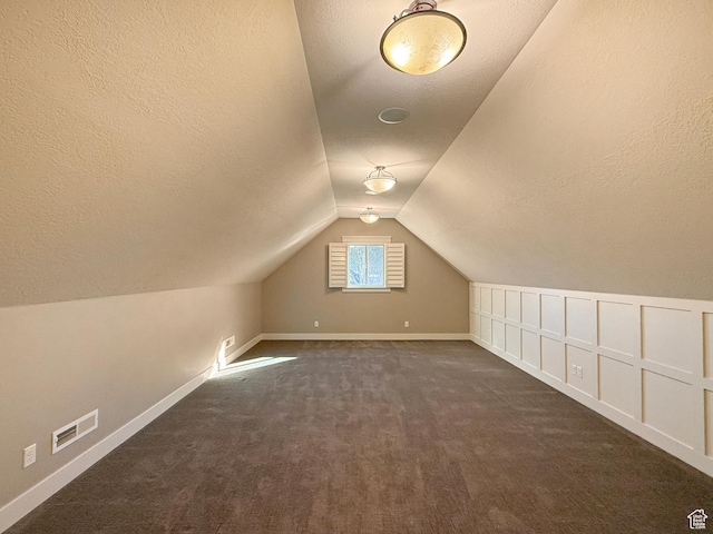 1663 N 3500 W, Plain City, UT 84404 - additional living space with lofted ceiling, visible vents, dark colored carpet, and a textured ceiling