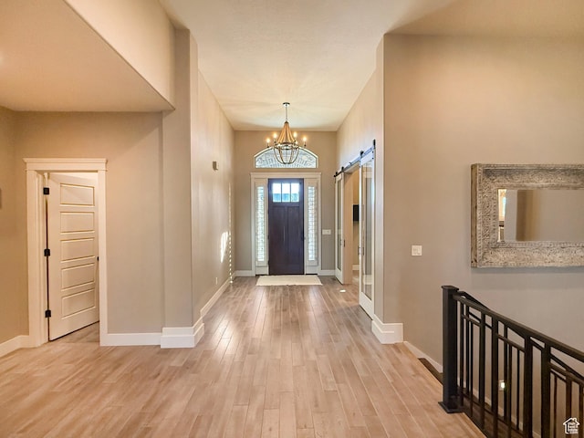 1663 N 3500 W, Plain City, UT 84404 - entrance foyer with an inviting chandelier, a barn door, baseboards, and wood finished floors