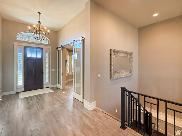 1663 N 3500 W, Plain City, UT 84404 - entrance foyer with a chandelier, a barn door, baseboards, and wood finished floors