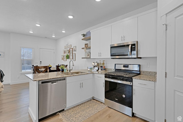 1189 W 1820 S Unit 13, Logan, UT 84321 - kitchen featuring appliances with stainless steel finishes, a sink, light wood finished floors, a peninsula, and recessed lighting