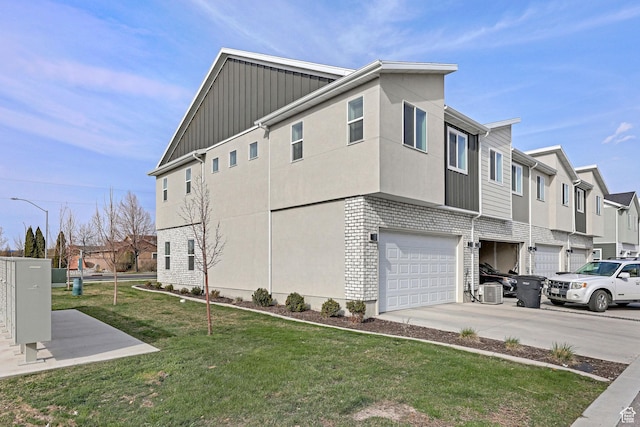 1189 W 1820 S Unit 13, Logan, UT 84321 - view of side of home with a garage, driveway, a lawn, a residential view, and board and batten siding