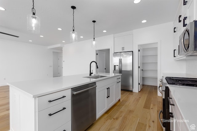 4085 E El Capitan Way, St George, UT 84790 - kitchen with decorative light fixtures, a center island with sink, stainless steel appliances, light wood finished floors, and a sink