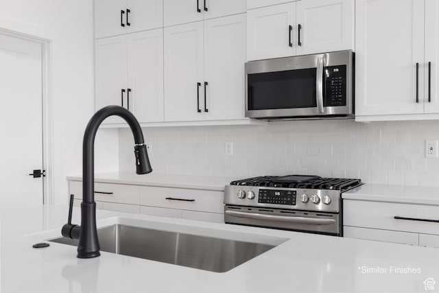 4085 E El Capitan Way, St George, UT 84790 - kitchen with tasteful backsplash, white cabinetry, appliances with stainless steel finishes, a sink, and light countertops