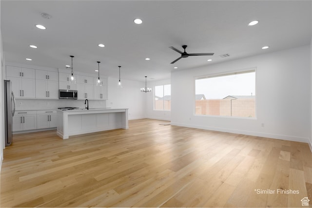 4085 E El Capitan Way, St George, UT 84790 - unfurnished living room with light wood-type flooring, ceiling fan with notable chandelier, baseboards, and recessed lighting