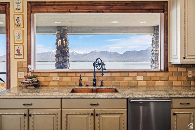1698 S Amanda Ln E, Saratoga Springs, UT 84045 - kitchen with tasteful backsplash, cream cabinetry, stainless steel dishwasher, a mountain view, and a sink