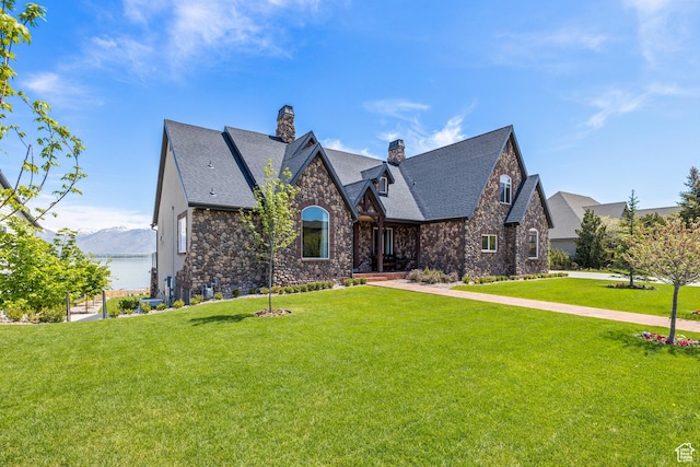 1698 S Amanda Ln E, Saratoga Springs, UT 84045 - view of front of home featuring stone siding, a front lawn, and a chimney