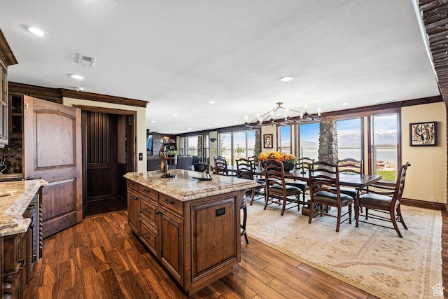 1698 S Amanda Ln E, Saratoga Springs, UT 84045 - kitchen featuring dark wood-type flooring, a kitchen bar, and a wealth of natural light