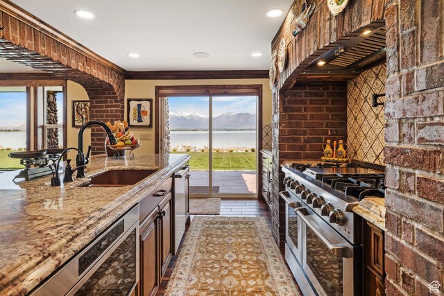 1698 S Amanda Ln E, Saratoga Springs, UT 84045 - kitchen featuring stainless steel appliances, a water view, a sink, light stone countertops, and wall chimney exhaust hood