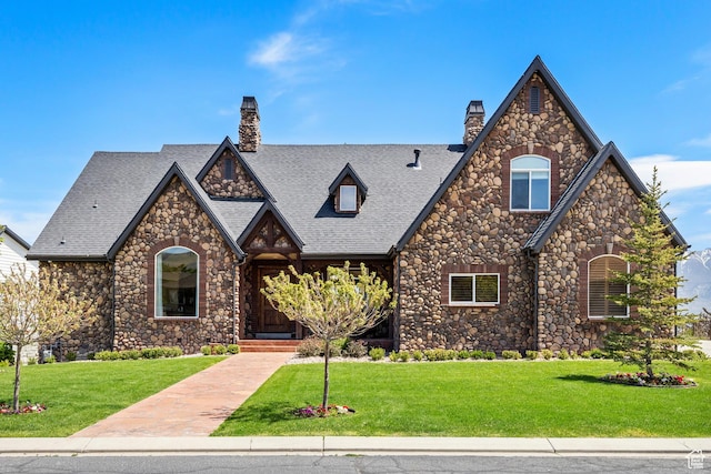 1698 S Amanda Ln E, Saratoga Springs, UT 84045 - english style home featuring a shingled roof, a chimney, and a front yard
