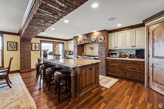 1698 S Amanda Ln E, Saratoga Springs, UT 84045 - kitchen with dark wood-type flooring, a sink, ornamental molding, decorative backsplash, and an island with sink