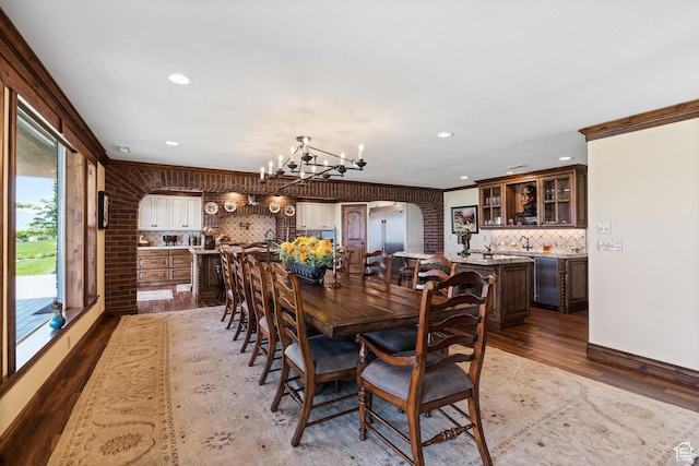 1698 S Amanda Ln E, Saratoga Springs, UT 84045 - dining space featuring ornamental molding, arched walkways, a notable chandelier, and wood finished floors