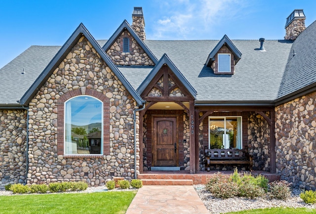 1698 S Amanda Ln E, Saratoga Springs, UT 84045 - entrance to property featuring a shingled roof, covered porch, and a chimney