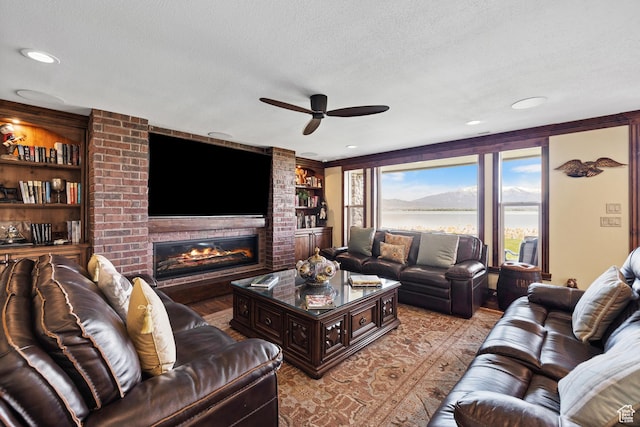 1698 S Amanda Ln E, Saratoga Springs, UT 84045 - living room with ceiling fan, a textured ceiling, built in shelves, a fireplace, and recessed lighting