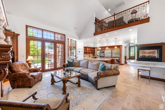 290 E 200 S, Parowan, UT 84761 - living room featuring french doors, stone tile flooring, visible vents, a towering ceiling, and a glass covered fireplace