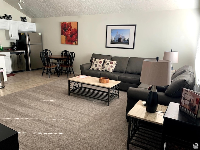 living area with lofted ceiling, light tile patterned flooring, and a textured ceiling