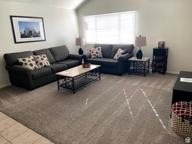 tiled living room featuring lofted ceiling, a textured ceiling, carpet, and baseboards