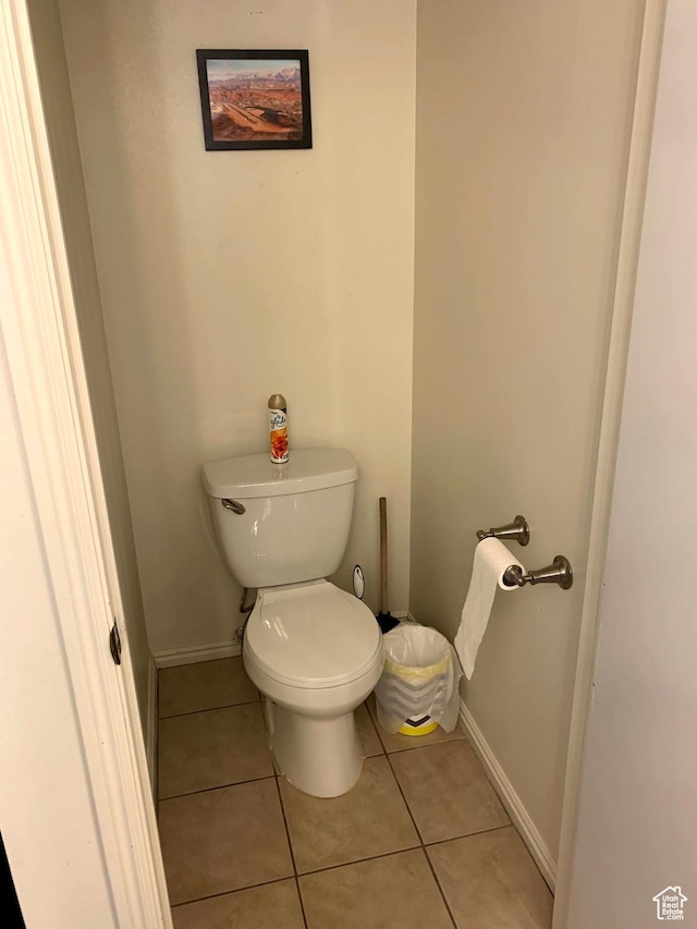 bathroom featuring toilet, tile patterned flooring, and baseboards
