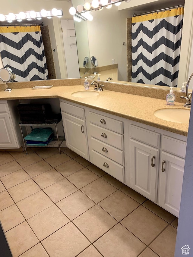 bathroom with double vanity, tile patterned flooring, and a sink