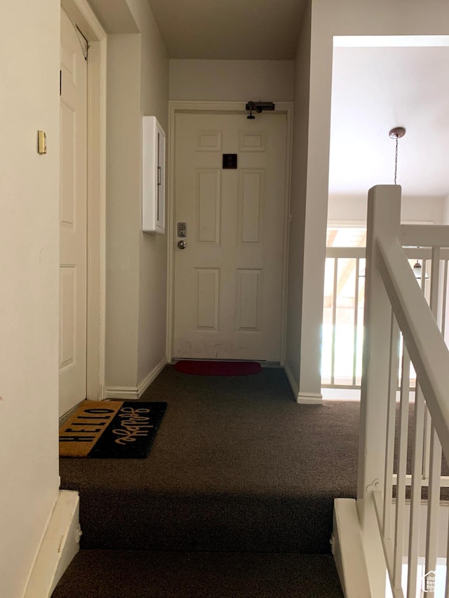 hallway featuring carpet floors, electric panel, baseboards, and an upstairs landing