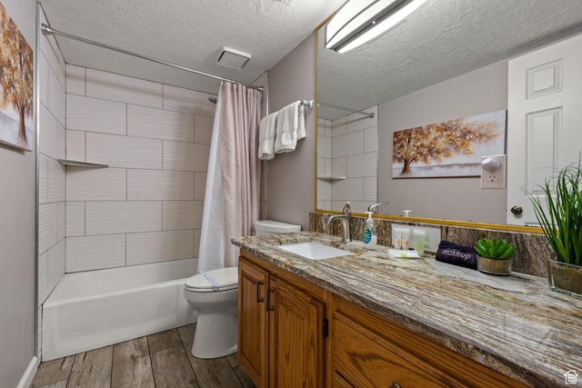 full bath with a textured ceiling, toilet, wood finished floors, vanity, and shower / bath combo with shower curtain