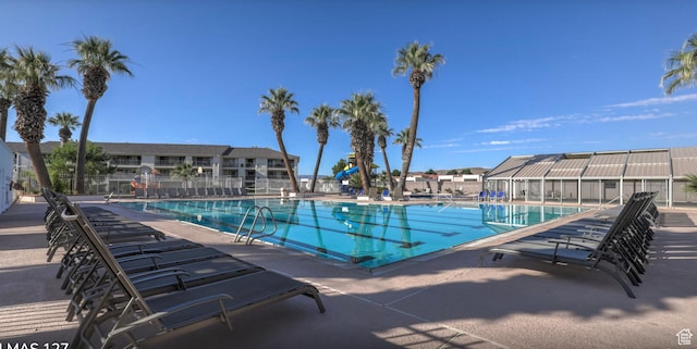 pool featuring a residential view, a patio area, and fence