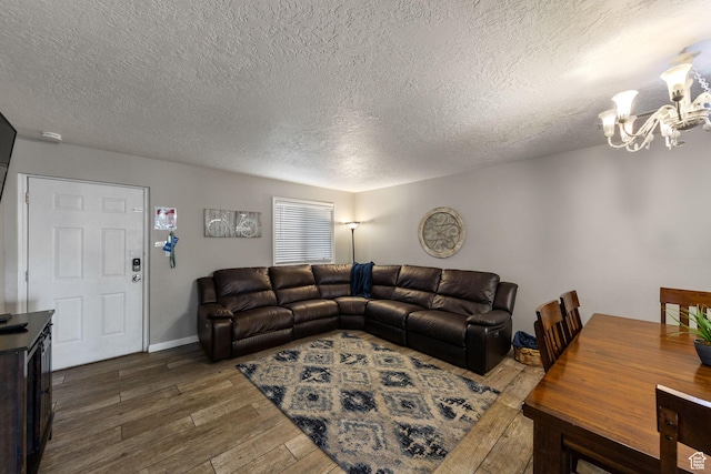living area with a textured ceiling, wood finished floors, and a notable chandelier