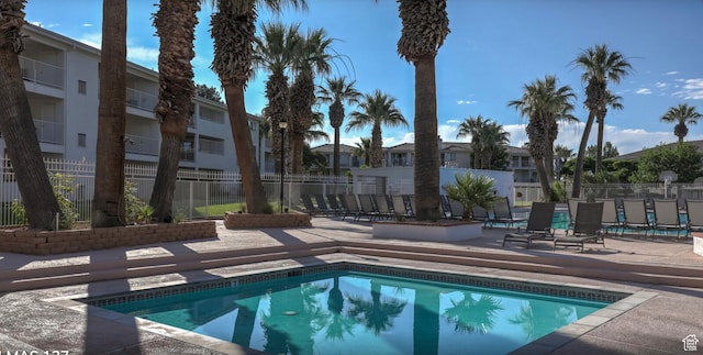 pool with a residential view, a patio area, and fence