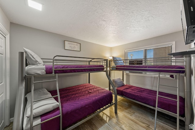 bedroom featuring wood-type flooring and a textured ceiling