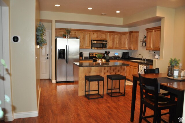 10611 S Oquirrh Lake Rd W, South Jordan, UT 84009 - kitchen with a sink, brown cabinets, stainless steel appliances, dark wood-style floors, and a kitchen island