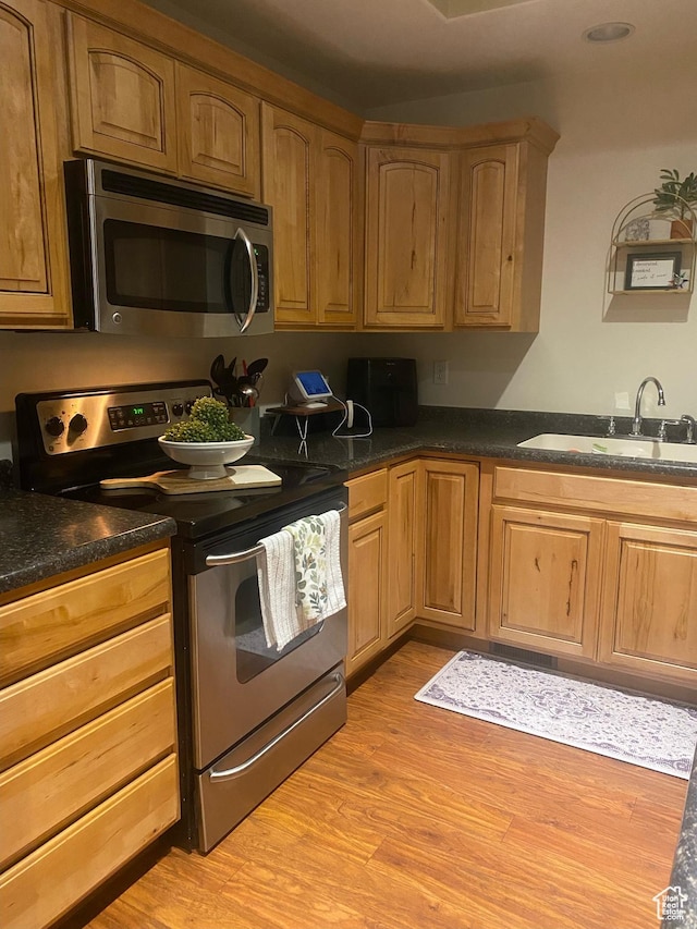 10611 S Oquirrh Lake Rd W, South Jordan, UT 84009 - kitchen with light wood-type flooring, stainless steel appliances, a sink, and dark countertops