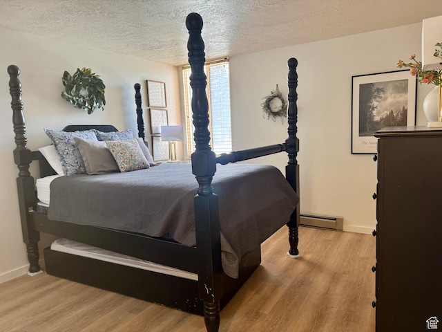 2176 S Bear Blvd Unit 316, & Garden City, UT 84028 - bedroom featuring a baseboard heating unit, light wood-style floors, a textured ceiling, and baseboards
