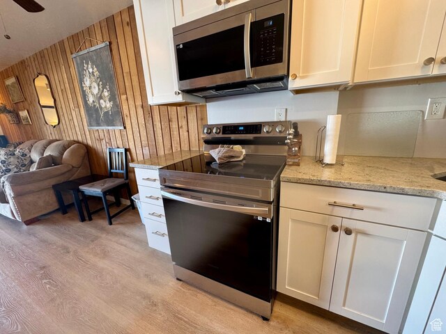 2176 S Bear Blvd Unit 316, & Garden City, UT 84028 - kitchen featuring light wood-type flooring, wooden walls, stainless steel appliances, and open floor plan