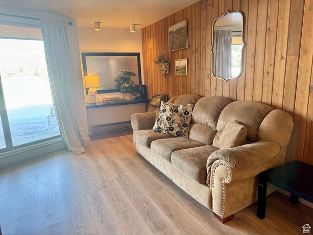 2176 S Bear Blvd Unit 316, & Garden City, UT 84028 - living room featuring a baseboard heating unit, wooden walls, and wood finished floors