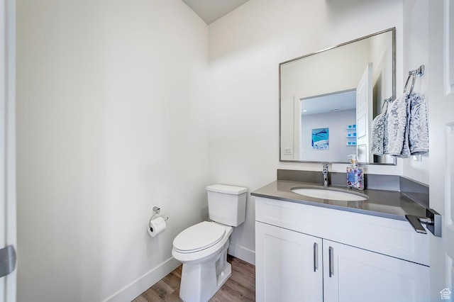 bathroom featuring wood finished floors, vanity, toilet, and baseboards