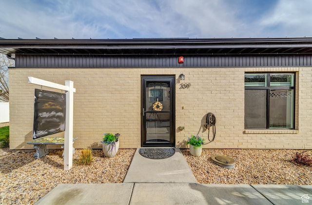 doorway to property featuring brick siding