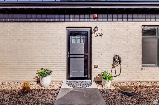 entrance to property featuring brick siding