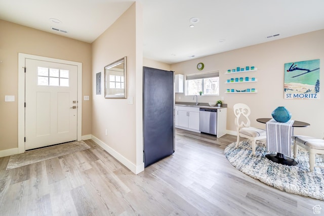 entrance foyer with light wood-type flooring, visible vents, and baseboards
