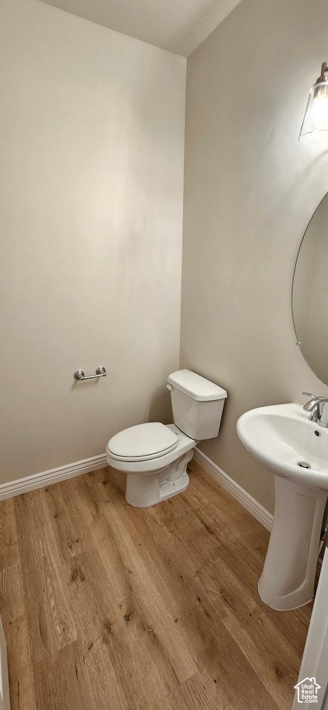 3392 E Stillwater, Eagle Mountain, UT 84005 - bathroom with a sink, baseboards, toilet, and wood finished floors