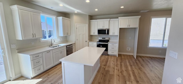 3392 E Stillwater, Eagle Mountain, UT 84005 - kitchen with stainless steel appliances, a sink, light wood-style flooring, and a center island