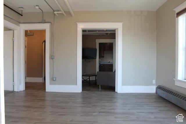 653 E 300 S, Salt Lake City, UT 84102 - unfurnished room with a baseboard radiator, baseboards, and wood finished floors