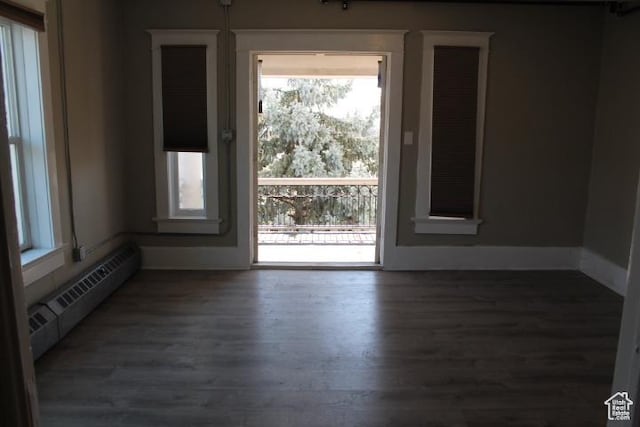 653 E 300 S, Salt Lake City, UT 84102 - unfurnished room with baseboard heating, wood finished floors, a wealth of natural light, and baseboards