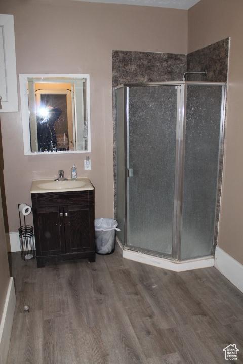 653 E 300 S, Salt Lake City, UT 84102 - bathroom with baseboards, wood finished floors, vanity, and a shower stall