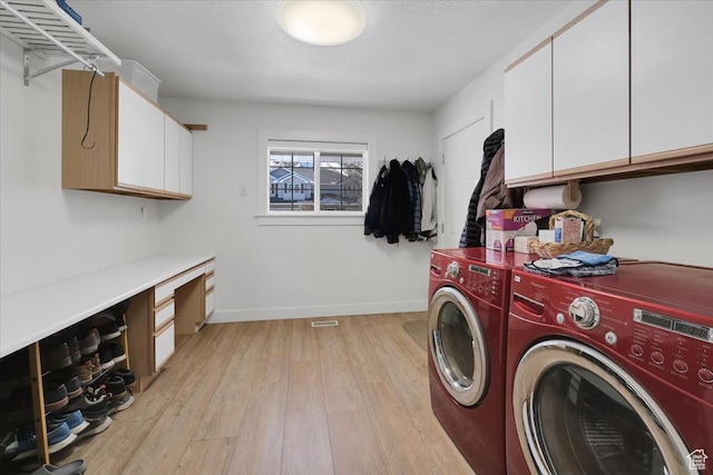 243 Eastridge E, Logan, UT 84321 - washroom featuring a textured ceiling, baseboards, light wood-type flooring, independent washer and dryer, and cabinet space