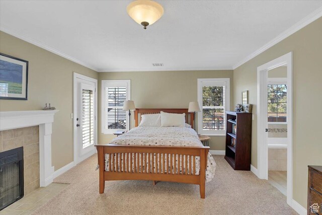 243 Eastridge E, Logan, UT 84321 - bedroom featuring ornamental molding, a tiled fireplace, visible vents, and light colored carpet