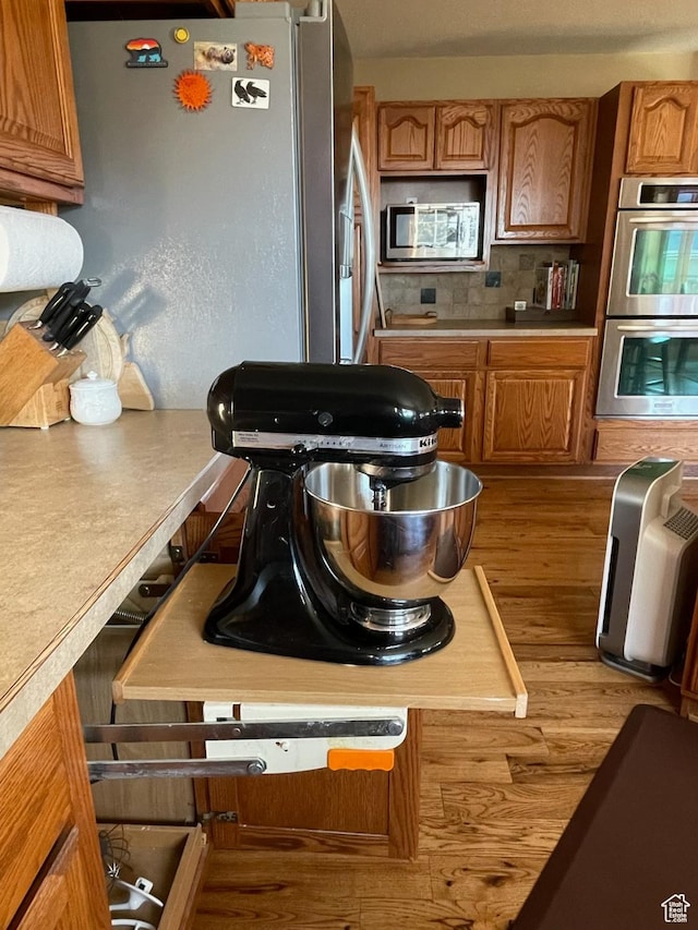 243 Eastridge E, Logan, UT 84321 - kitchen with stainless steel appliances, light countertops, brown cabinets, and wood finished floors