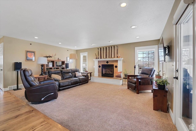 243 Eastridge E, Logan, UT 84321 - living room with recessed lighting, a fireplace with raised hearth, a textured ceiling, and baseboards
