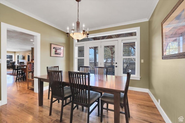 243 Eastridge E, Logan, UT 84321 - dining space featuring a chandelier, crown molding, baseboards, and wood finished floors