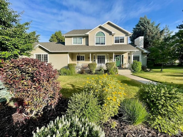 243 Eastridge E, Logan, UT 84321 - view of front facade with a front lawn, a porch, and a chimney